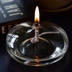 Laboratorie-ljus i glas med tänd låga, idealisk för vetenskaplig dekoration eller för att skapa en varm atmosfär i en arbetsmiljö.