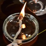Laboratorie-ljus i glas med tänd veke, som skapar en stark låga.