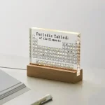Modell av det periodiska systemet av elementen i transparent akryl, presenterad på en träställning, idealisk för vetenskaplig och pedagogisk dekoration.