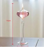 Transparent glasljusstake med tänd ljus, 14 cm hög, idealisk för bordsdekoration eller varm atmosfär.