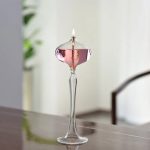 Blåst glasvas med tänd låga, elegant och modern design, perfekt för inredning eller som vetenskapligt samlarobjekt.