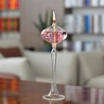 Glasljusvas med rosa vätska och tänd låga, elegant vetenskaplig dekoration.