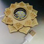 Solfjäderformad LED-lampa i trä med graverad design, perfekt för vetenskaplig eller pedagogisk dekoration. Fungerar med USB-kabel för praktisk användning.