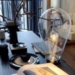 Dekorativ lampa i vetenskaplig stil i glas med lysande filament, perfekt för modern eller vetenskaplig tematisk dekoration i ett samtida hem.