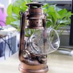 Vintage oljelampa i koppar med glas, perfekt för inredning inomhus eller samling.