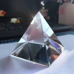 Transparent kristallpyramid med ljusreflexer, perfekt för vetenskaplig dekoration eller som samlarobjekt.