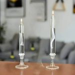 Två laboratorieljus i glas med inre spiral, placerade på en träyta, i en modern och ren inomhusmiljö.