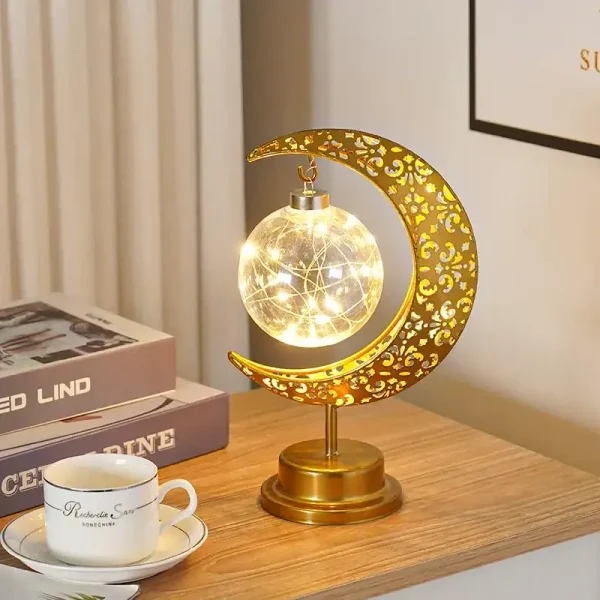 Dekorativ månlampa med stjärnfall, varm LED-belysning, elegant design i guldmetall, perfekt för inredning eller kontor.
