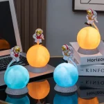 Lysande astronautfigurer på färgglada sfärer, science fiction-dekorationer för kontor eller hylla.