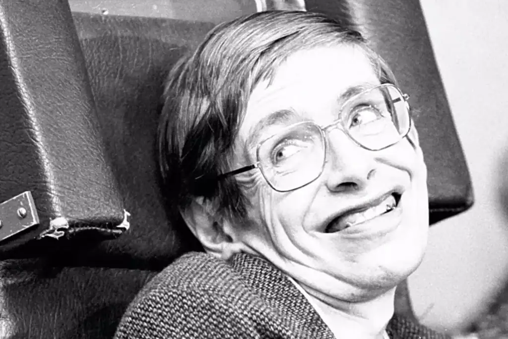 Svartvitt porträtt av en leende man med glasögon, som påminner om en vetenskapsman eller professor, i retrostil.