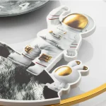 Nyckelring i form av en astronaut med upphöjd design och gyllene hjälm, perfekt för vetenskaps- och rymdentusiaster, idealisk som tillbehör eller dekoration.