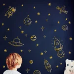 Utbildningsspel med rymdtema med raketer, planeter och astronauter i gyllene illustration på natthimmel.