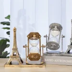 Miniatyr Eiffeltorn och dekorativ timer i glas och guldmetall, perfekta för en vetenskaplig eller vintage dekoration.