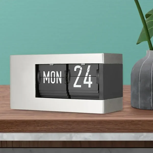 Vintage flip-kalender i svart och vitt på ett träbord, dekorativ och praktisk för att visa datumet.