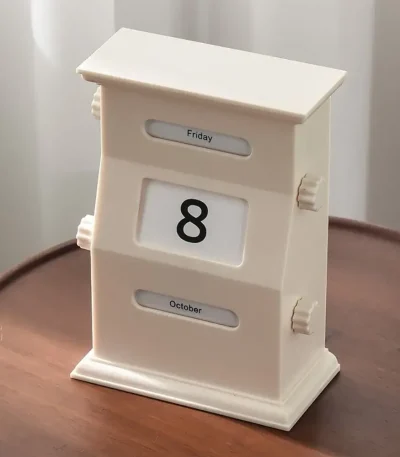 Vintage kontorskalender i form av möbel med visning av dag, månad och datum, perfekt för vetenskaplig eller retro dekoration.