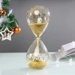 Timglas i klart glas med långsamt flödande gyllene sand, perfekt för dekoration eller som samlarobjekt.