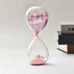 Dekorativ sandur i glas med rosa paljetter, perfekt för inredning eller som samlarobjekt. Elegant och modern design, idealisk för vetenskaplig eller a.
