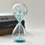 Vetenskaplig sandur i glas med blå sand, symbol för tidens mätning, perfekt för skrivbords- eller vetenskaplig studiedekoration.