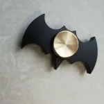 Dekorationsaccessoar inspirerad av Batman, i form av en batarang med en roterande mekanism i guldmetall.