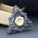 Dekorativ fidget spinner i metall med blå detaljer och komplex design, perfekt för dekoration eller samling.
