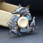 Fidget spinner i metall med delfindesign, japanska symboler och blå detaljer, perfekt för dekoration eller avkoppling.