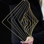 Dekorativ skulptur i gyllene metalltråd, modern geometrisk form för inredning eller kontor.