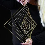Geometrisk pendel i guldtråd, modern och elegant smycke, perfekt för dekoration eller bärande. Minimalistisk design med geometriska former i fin guldtråd.