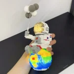 Modell av rymdskepp i LEGO-block med meteorballong, utställd i en mänsklig hand, som illustrerar en kreativ vetenskaplig inredning.