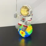 LEGO-figur av astronaut med gyllene hjälm, sittande på en färgglad planet, som representerar en lekfull och kreativ rymdscen.