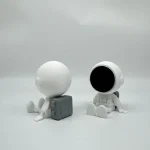 Minimalistiska astronautfigurer i vitt, sittande på en vit bakgrund, med en ren och modern design, perfekta för vetenskaplig eller tematisk inredning.