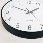 Väggklocka i quartz med tydlig och exakt visning, idealisk för vetenskaplig eller kontorsinredning. Ren design med svarta siffror på vit bakgrund, lätt att läsa.