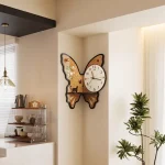Väggklocka i form av en fjäril med blommig och djurdekoration, elegant design för inredning.