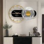 Modern väggklocka med geometriska element i svart, vitt och guld, dekorativ och funktionell för ett samtida hem.