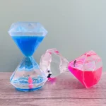 Dekorativ sandur med blå, rosa och transparent vätska, i form av kristaller, perfekt för vetenskaplig eller modern dekoration.
