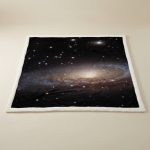 Trycktyg som föreställer en avlägsen galax med stjärnor och nebulosor, perfekt för vetenskaplig inredning eller för astronomientusiaster.