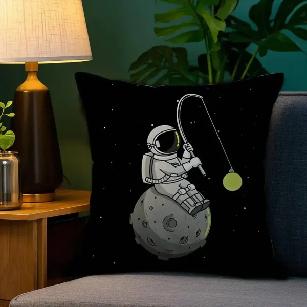 Kudde med design av en astronaut som fiskar i rymden, placerad på en soffa.