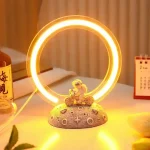 Vetenskaplig lampa med ljusring och figur, idealisk för kontors- eller rumsinredning, som ger en modern och lekfull touch till ditt utrymme.