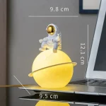 Dekorativt objekt med astronaut och lysande planet.