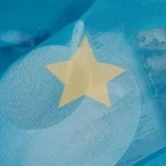 Pappersstjärna i transparent material med blå bakgrund, som framhäver texturen och lättheten i materialet, idealisk för vetenskaplig eller utbildande inredning.