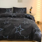 Duvetöverdrag och örngott med mönster av stjärnor och galaxer i en kosmisk design.