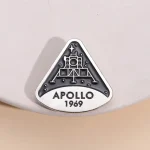 En brosch eller märke som föreställer NASA:s Apollo 11-mission, med datumet 1969, en ikonisk symbol för rymdutforskning.