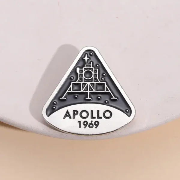 En brosch eller märke som föreställer NASA:s Apollo 11-mission, med datumet 1969, en ikonisk symbol för rymdutforskning.