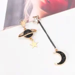 Handväsksnålar med astronomimönster, stjärnor och måne, i guldmetall med svarta och klara detaljer, perfekta för modeaccessoarer inspirerade av rymden.