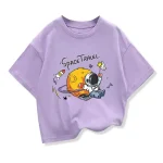 Lila T-shirt med motiv av astronaut och måne, lekfull design för rymd- och vetenskapsentusiaster.