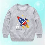 Barnplagg i grått med illustration av färgglad raket och stjärnor, perfekt för vetenskaps- och astronomiälskare.