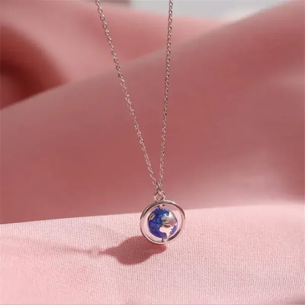 Halsband med miniatyrhäng av jordklot i silver, symbol för resa och upptäckter.