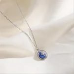 Delikat halsband med hänge av planeten Jorden i blått glas och silver.