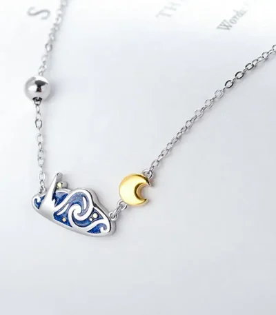 Delikat halsband med hänge av guldmåne och konstellation i silver, perfekt för astronomientusiaster och vetenskap.