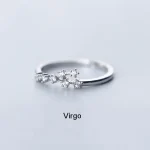 Jungfruring i silver med glänsande kristaller, symbol för stjärntecknet, elegant och raffinerad, idealisk för älskare av astrologiska smycken.