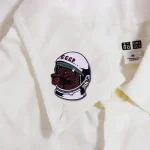 Astronautpatch med sovjetiskt ansikte på ett vitt plagg, symbol för rymdutforskning och sovjetisk historia.